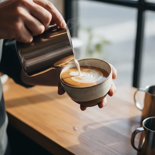 Coffee being poured into a ceramic cup